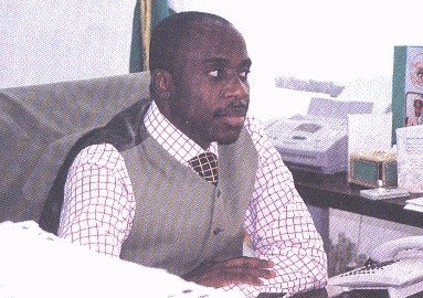 A photograph of a smartly-dressed man in an office