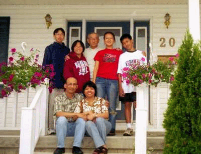 A photograph of a family sitting outside a house