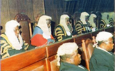 A photograph of a number of barristers in formal dress and wigs in court